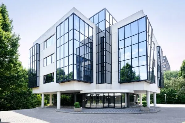 Modern kantoorgebouw aan de Max Euwelaan met grote glazen gevels en witte betonelementen.